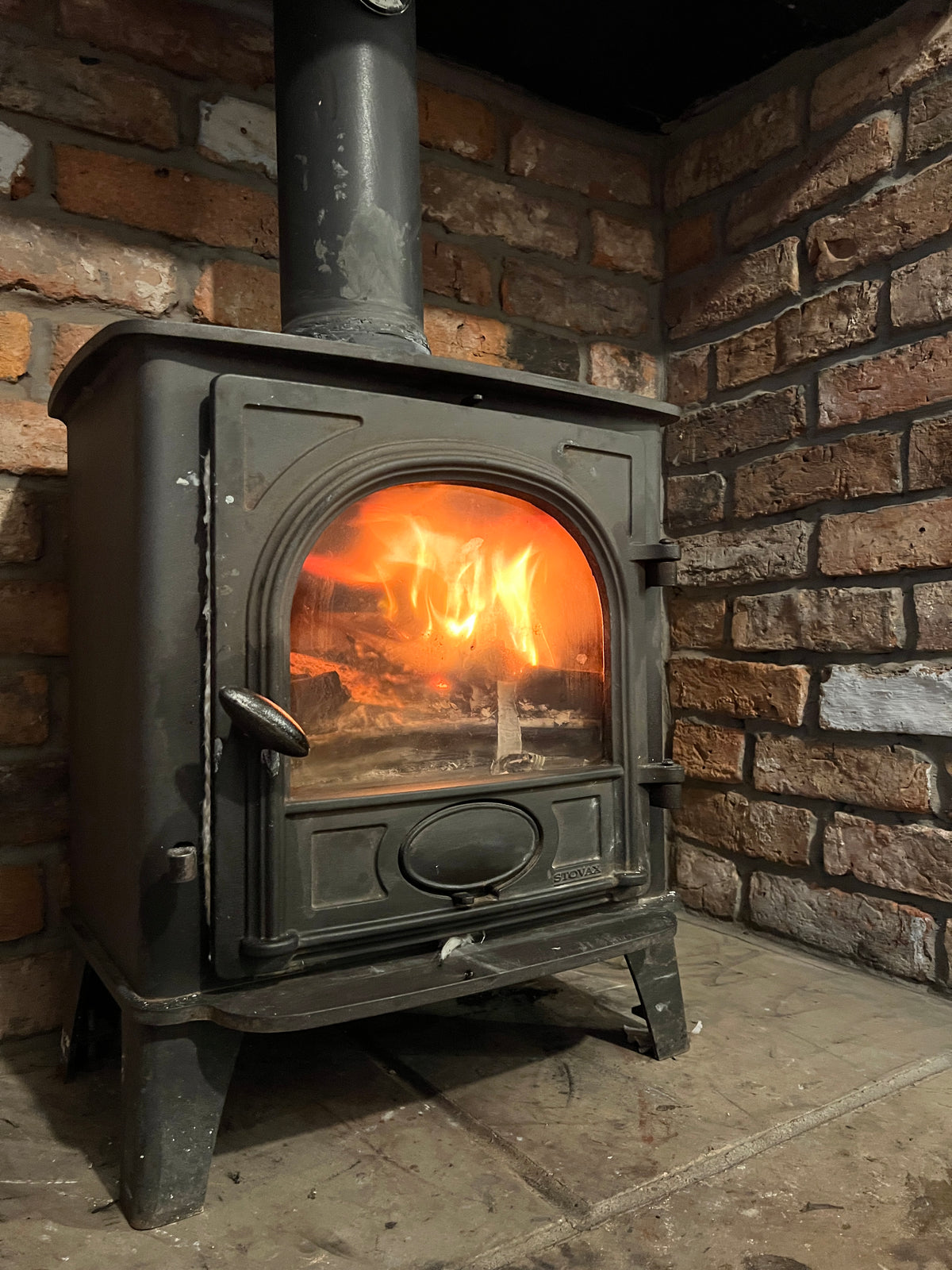 Traditional wood burning stove with reclaimed brick surround