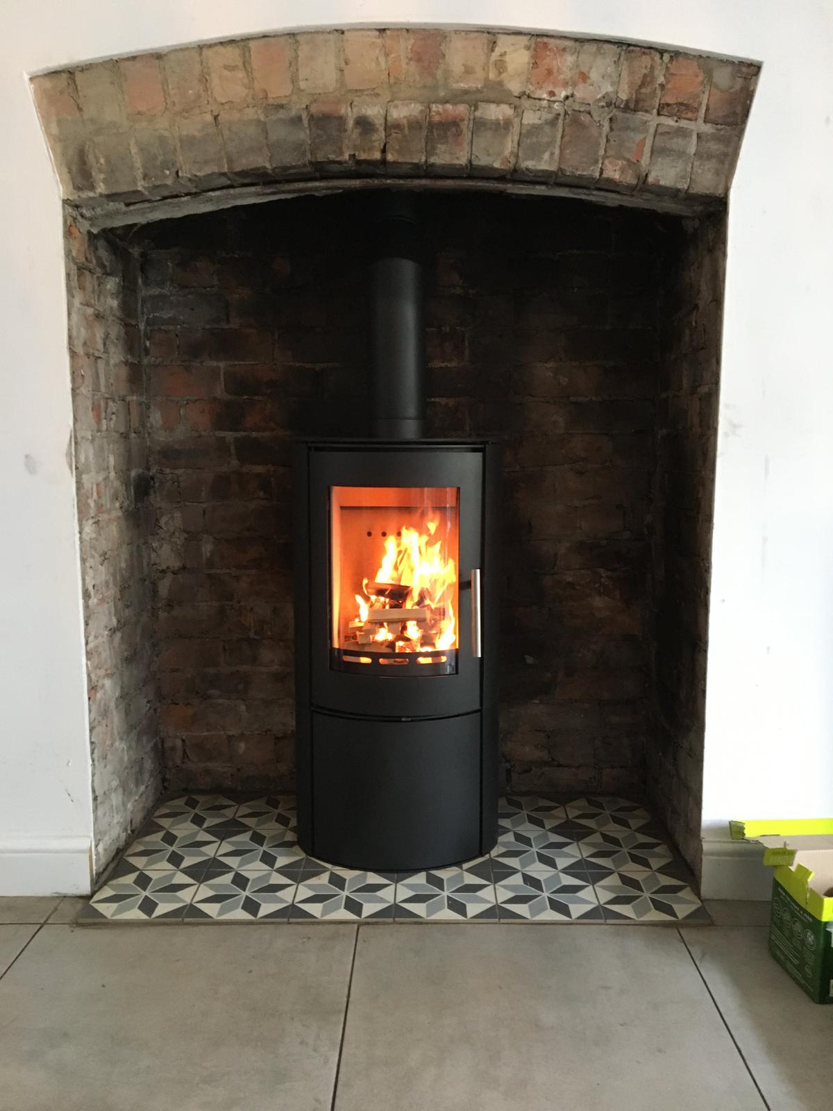 Stove in brick arch with geometric tile hearth