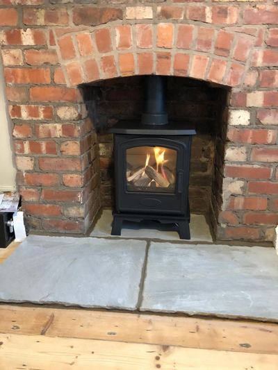 Stove installation in brick arch with fire lit