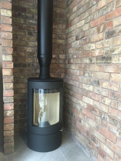 Cylindrical stove against brick feature wall